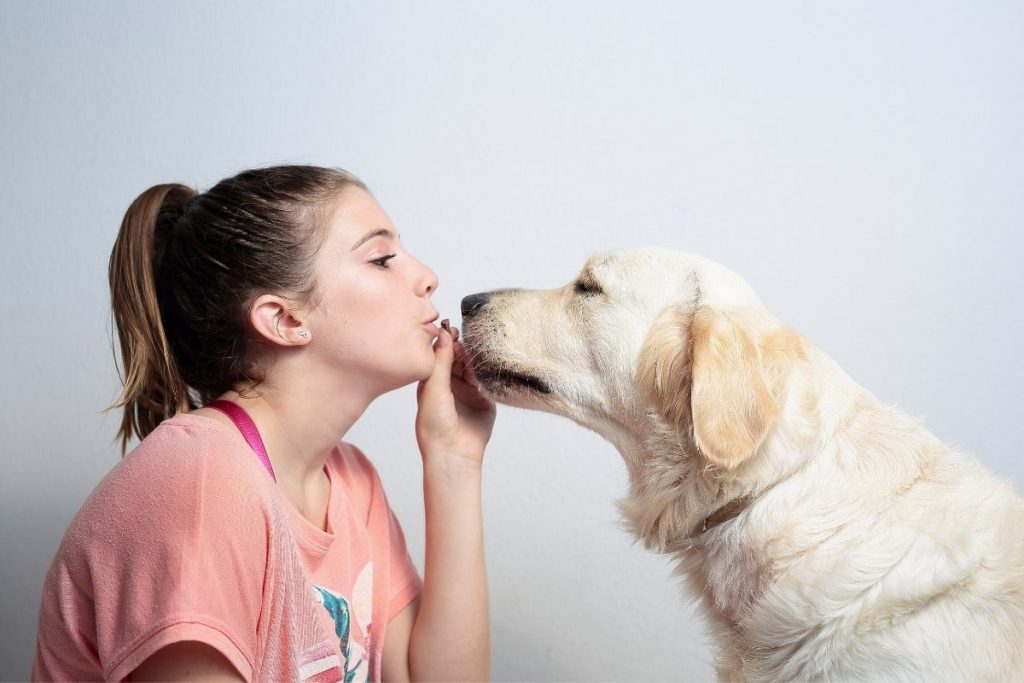 Teen kissing her emotional support labrador retriever