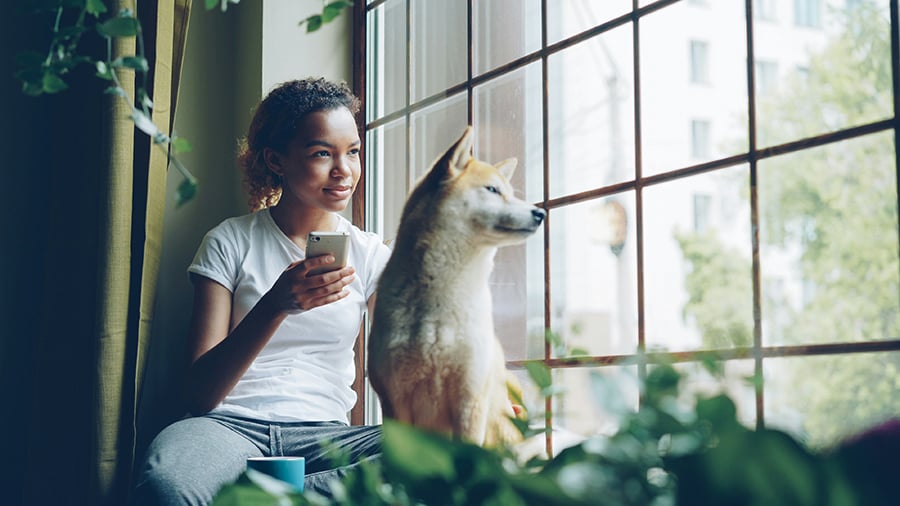 Which Type of Assistance Animal Is Best? 6 Woman looking out the window with an emotional support dog.